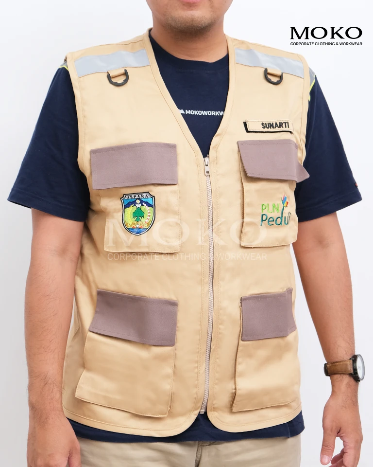 Rompi kantor custom warna krem dengan kantong multifungsi, bordir logo perusahaan, dan desain profesional untuk operasional lapangan dan instansi.
