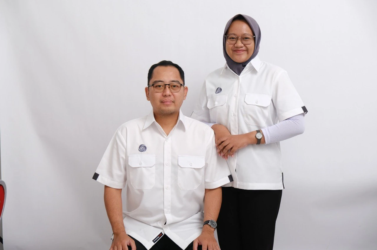 7 Jenis Seragam Kerja Populer untuk Berbagai Bidang Usaha di Indonesia 2 Model pria dan wanita mengenakan seragam kerja putih custom produksi Garment Indonesia dengan desain profesional untuk perusahaan, instansi, dan industri.
