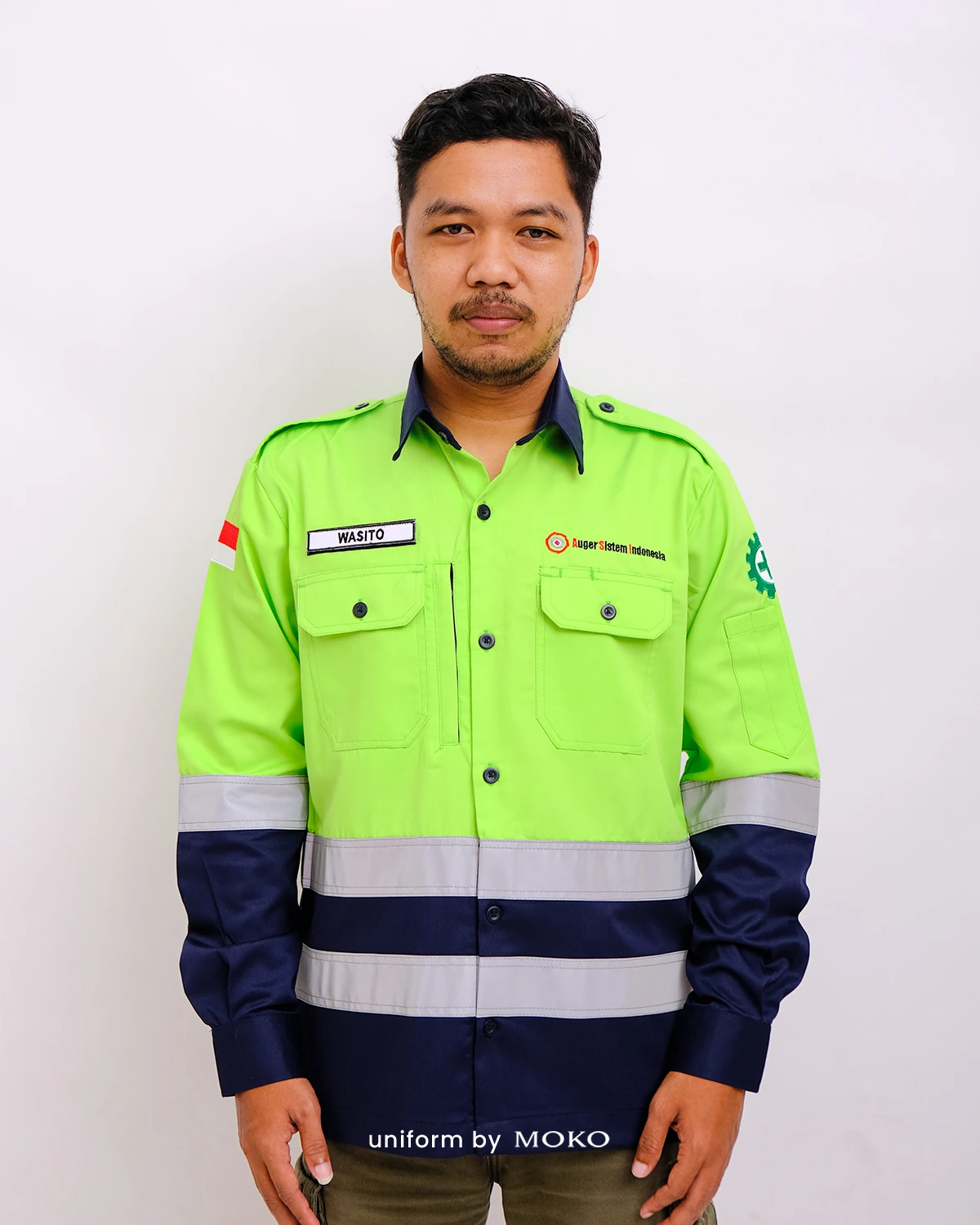 Wearpack safety custom warna hijau stabilo dan biru navy dengan reflective tape, bordir logo perusahaan, serta desain lengan panjang untuk kebutuhan industri dan proyek.